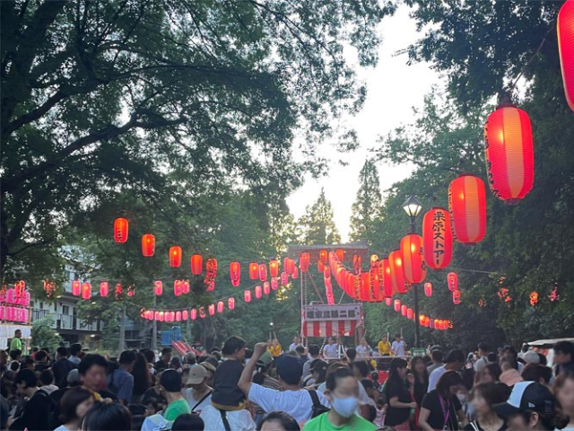 井の頭ふれあい盆踊り大会の会場2025。夕暮れ時に提灯が並び、多くの来場者でにぎわっている様子